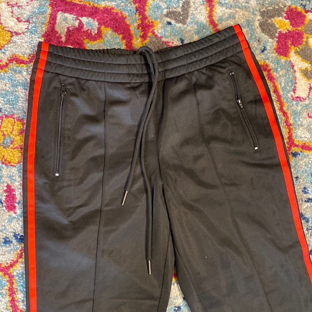 Black track pants with red stripe